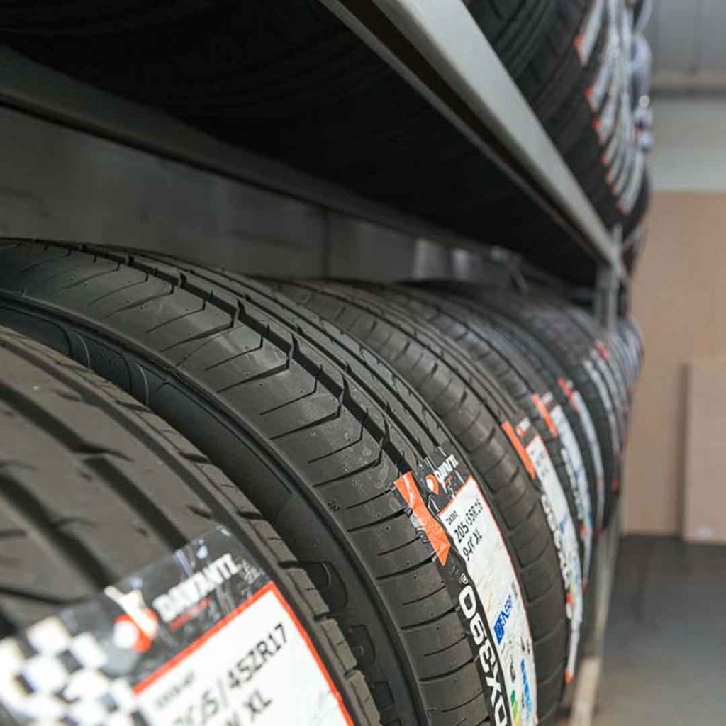 Display of tyres for every season lined up on a shelf at Motorvation Northampton, showcasing different sizes and brands available.