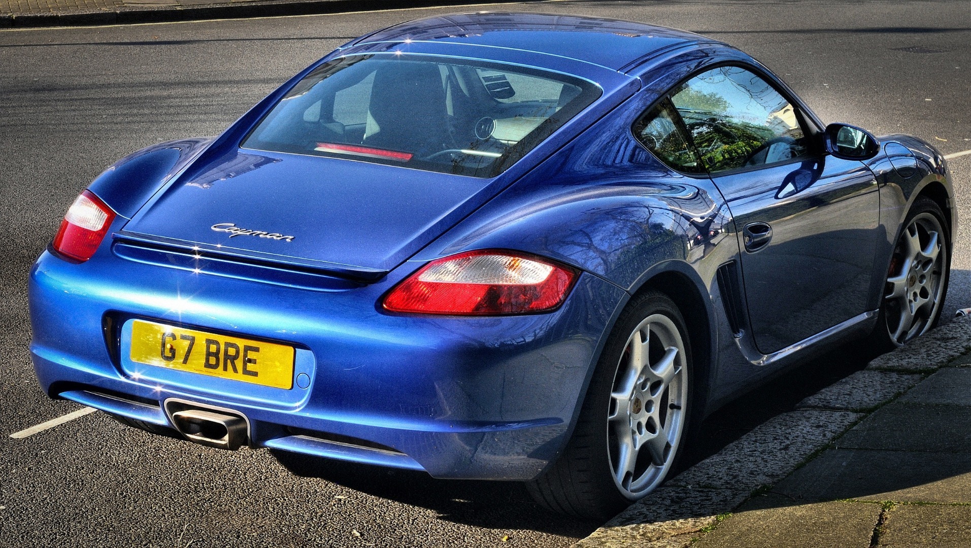 Back view of a blue Porsche Cayman