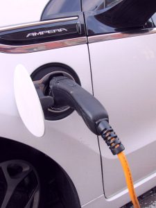 Electric pump plugged into white hybrid car
