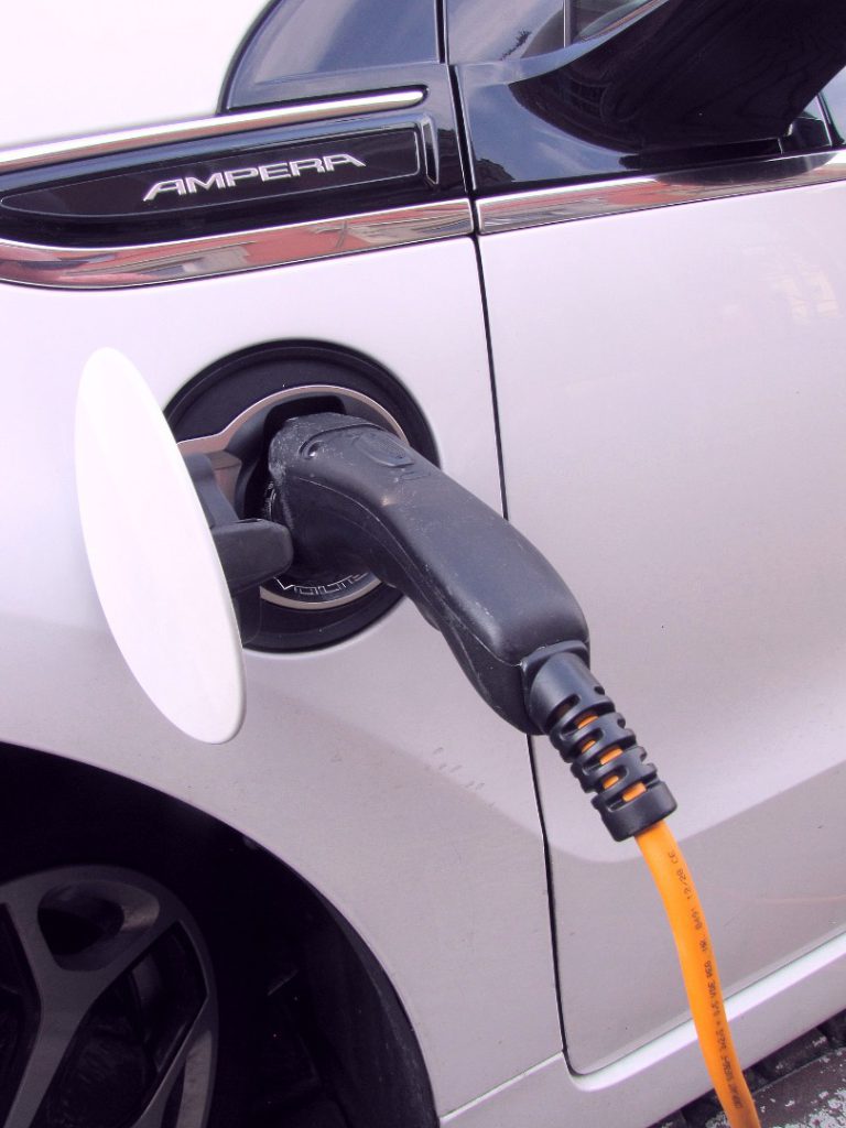 Electric pump plugged into white hybrid car