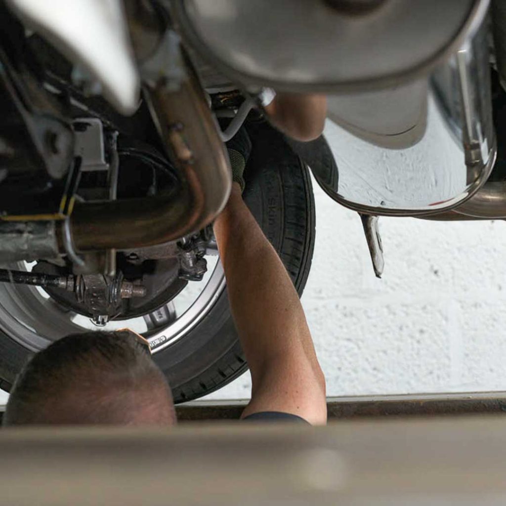 Motorvation Northampton technician inspecting undecarriage of a car during an MOT in Northampton.