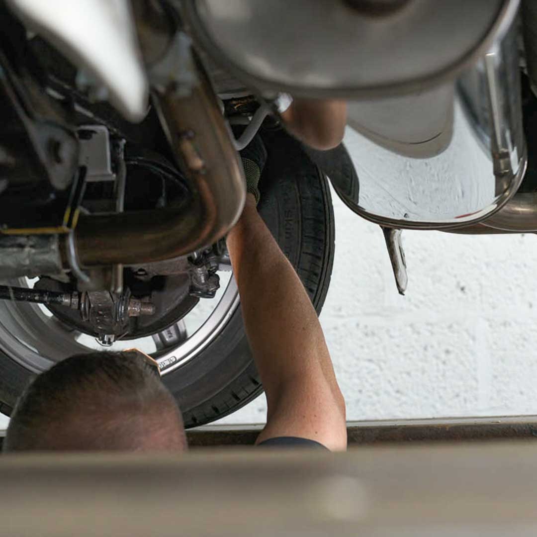 Motorvation Northampton technician inspecting undecarriage of a car during an MOT in Northampton.