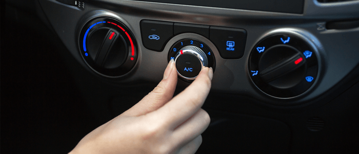 Hand turning dial of aircon in a car