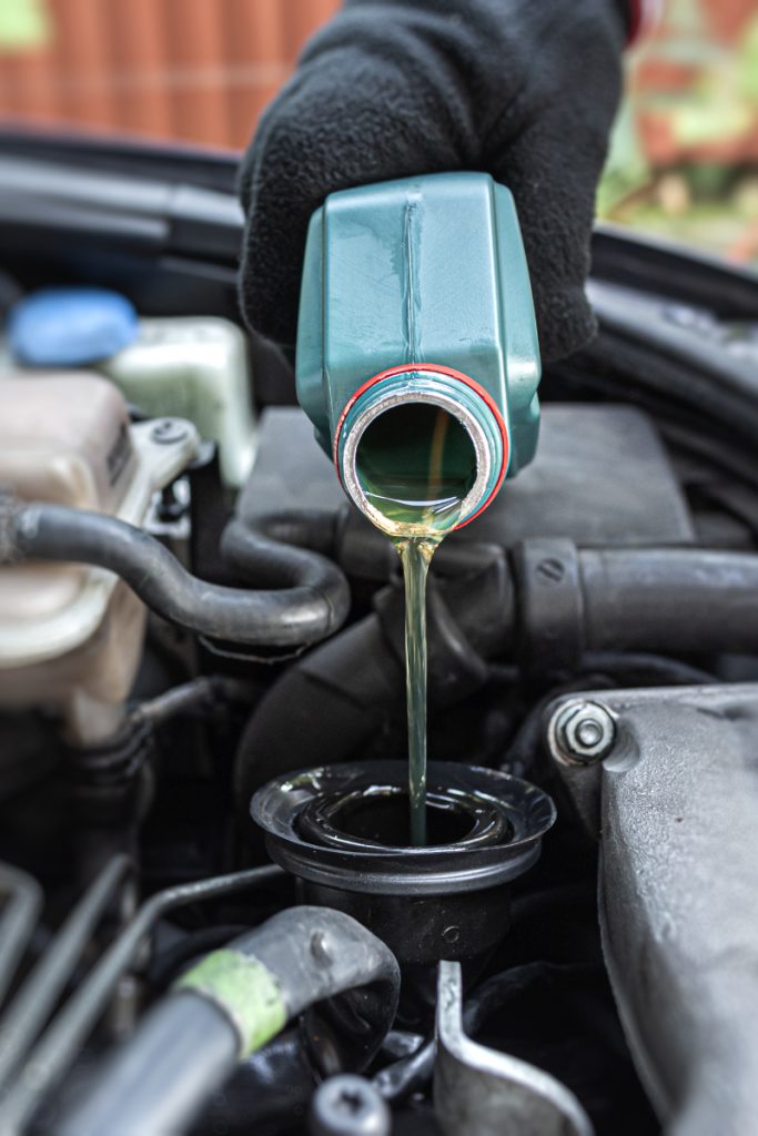 Motor oil being poured into car engine as part of car service in Northampton